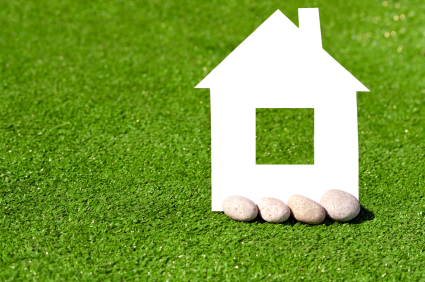 cardboard house with stones against the green grass